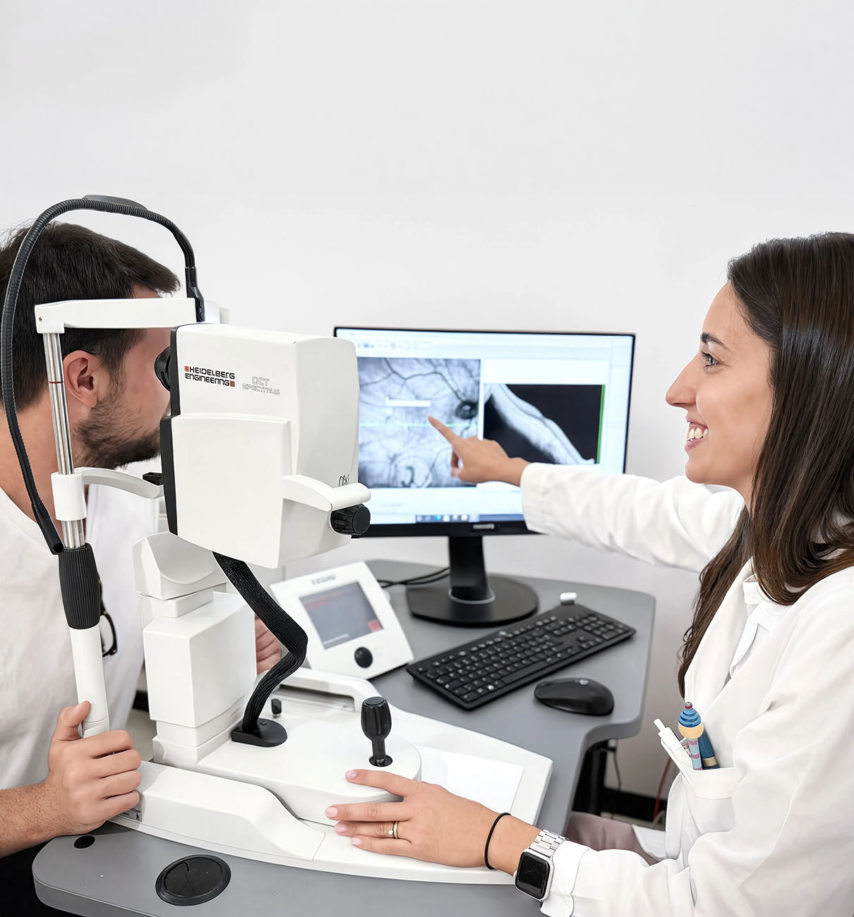 Oculista mostra al paziente i risultati dell'esame OCT su schermo durante una visita di controllo per difetti visivi.